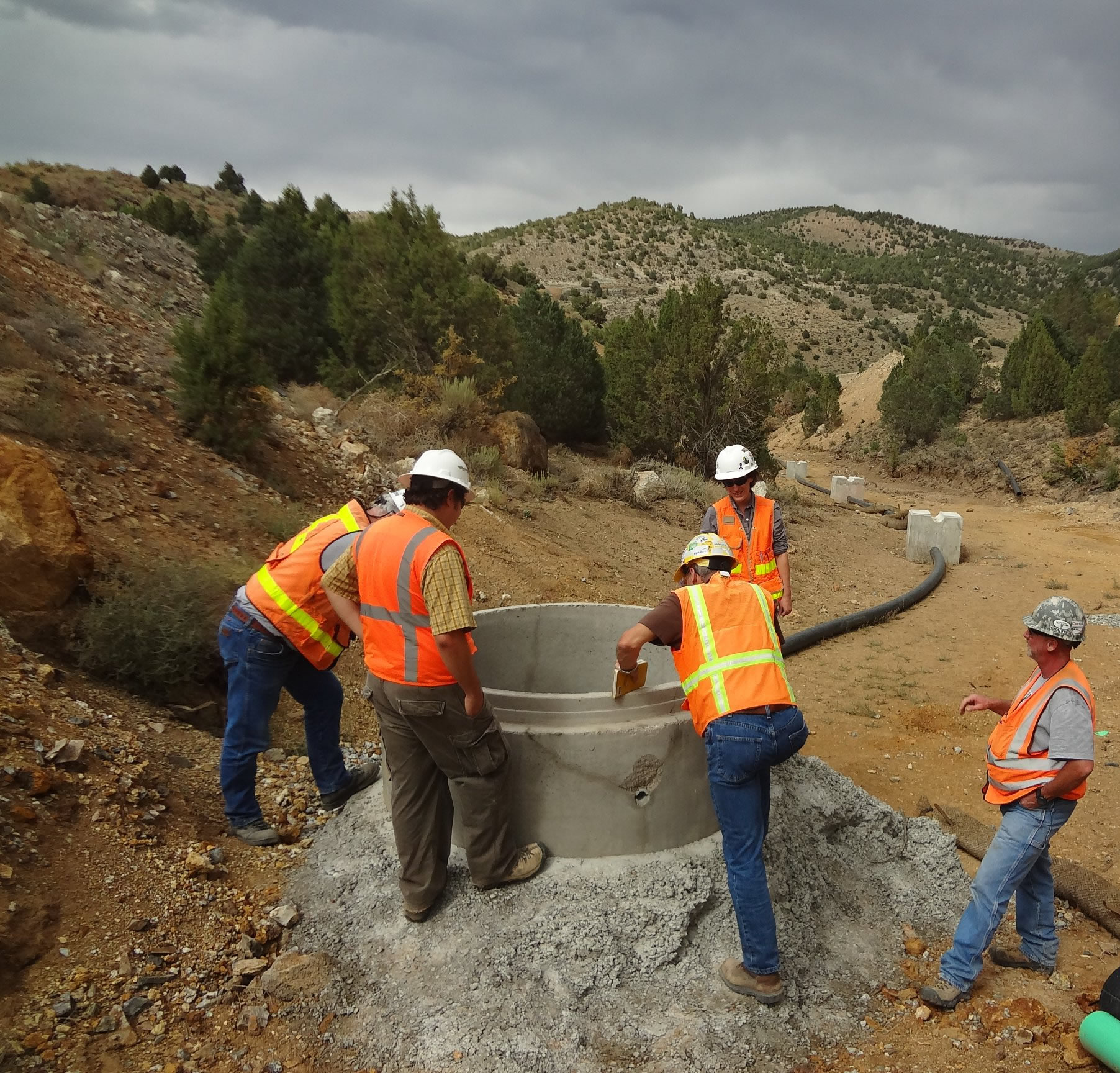 BMRR employees inspecting a sump near a mine site.
