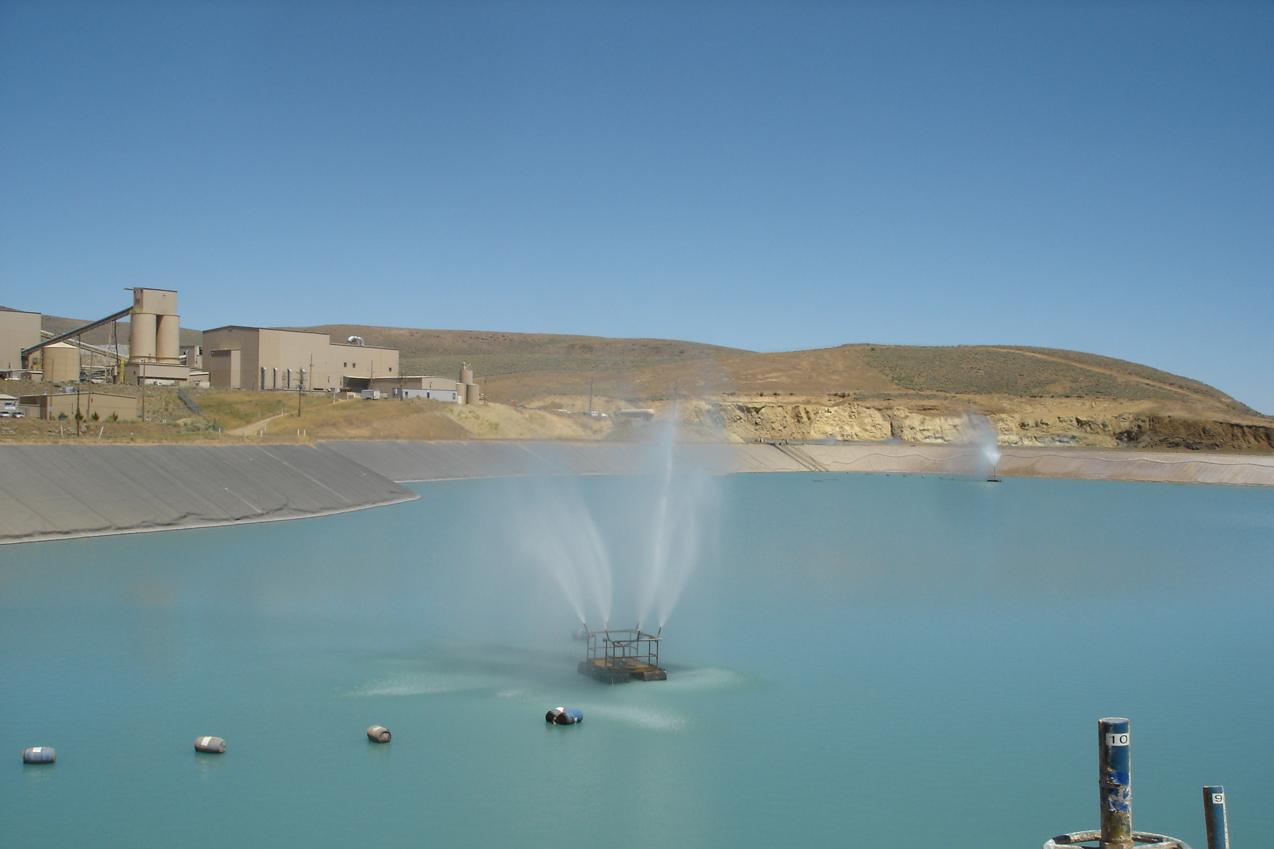 Tailings impoundment with evaporation sprinklers in operation.